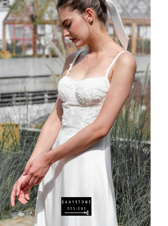 Model posing in the elegant satin dress with 3D floral lace in an outdoor setting.