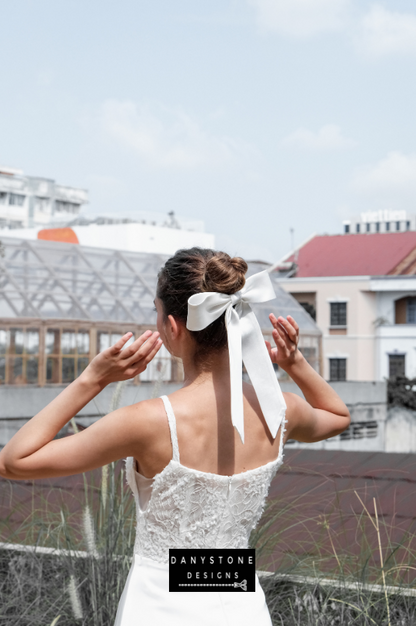 A back view of the elegant satin dress with a ribbon detail in the hair.