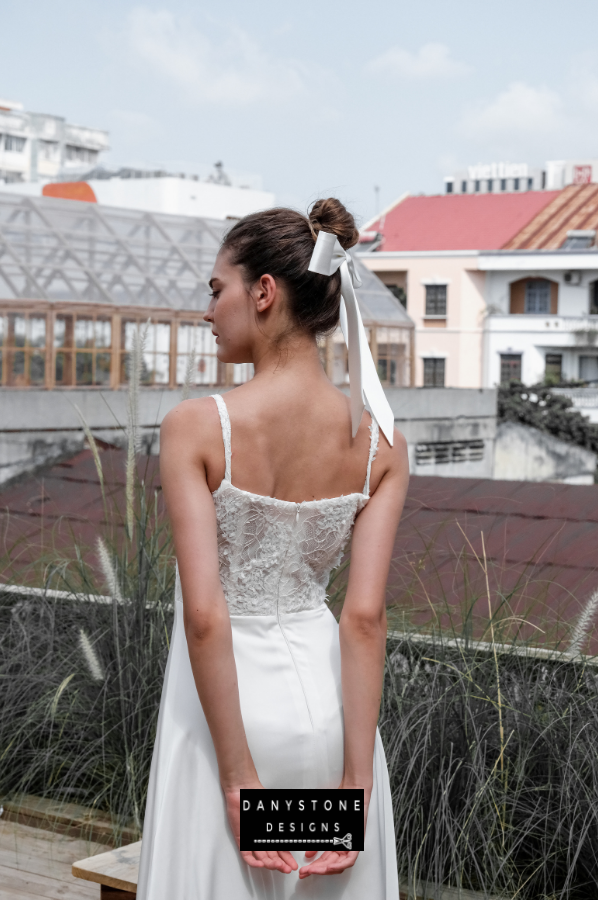 A side view of the satin dress showcasing the lace bodice and flowing skirt.