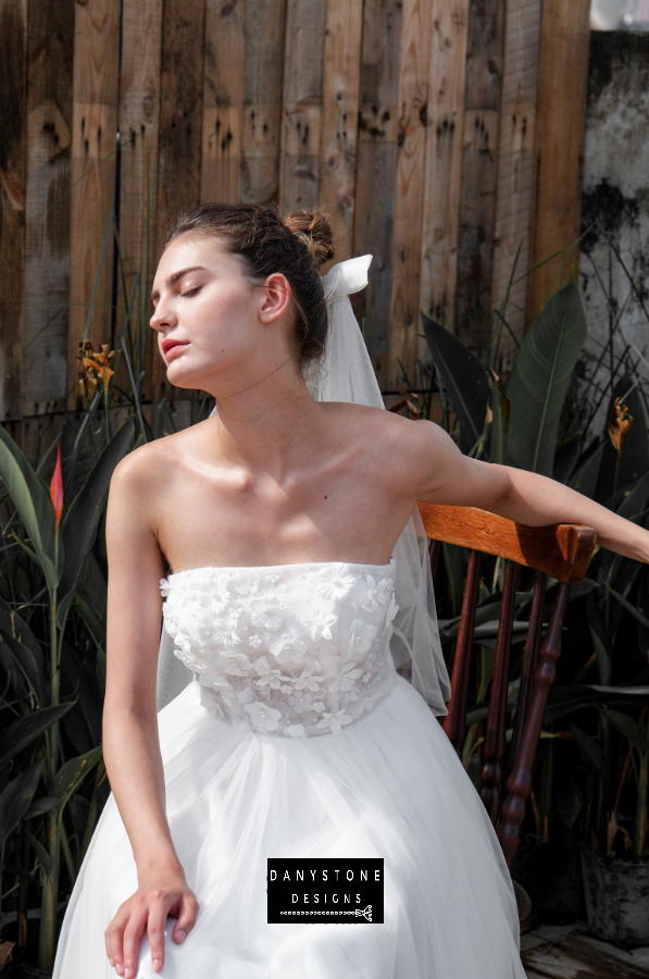 Model sitting and showcasing the elegance of the mini dress with 3D flower appliqué and mesh details.