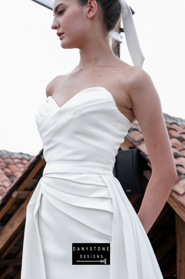 Sophisticated Pleated Bustier Gown - Side view of the model showcasing the pleated bustier and flowing skirt.