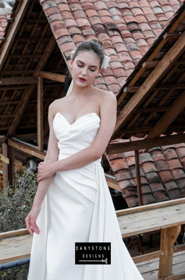 Timeless Strapless Gown with Pleats - Close-up of the model highlighting the intricate pleating on the bustier.