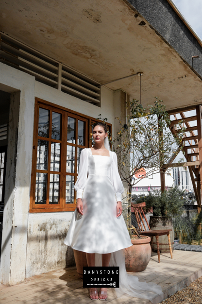 Elegant Square Neck Wedding Dress - Model posing in the elegant square neck wedding dress with long sleeves and button details.