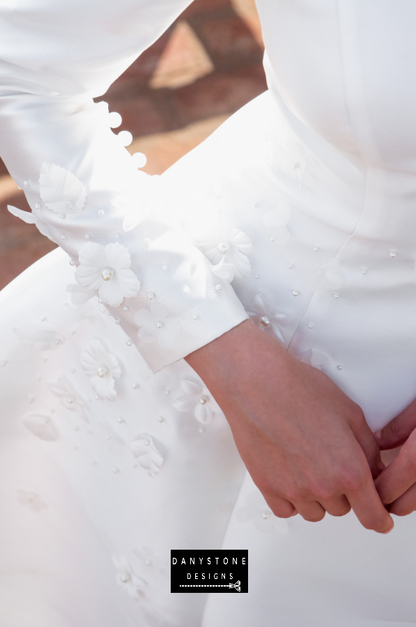  A close-up view of the embossed flower detailing on the 7-piece tafta dress with long sleeves.