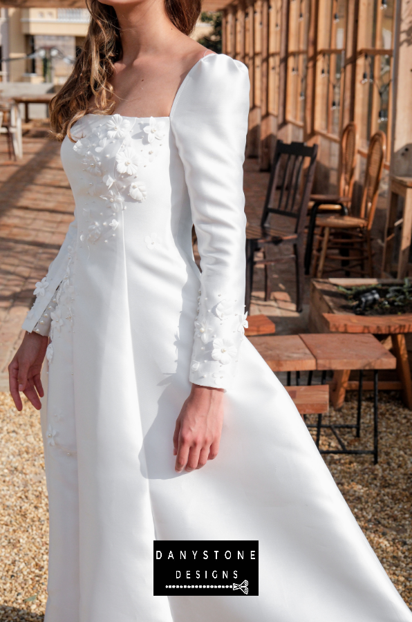  Model posing in the 7-piece tafta dress with embossed flowers, highlighting the details.