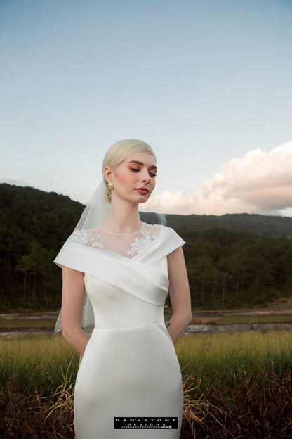 Image 4: Elegant bride in a satin mermaid wedding dress with floral appliqué, standing confidently by the water.