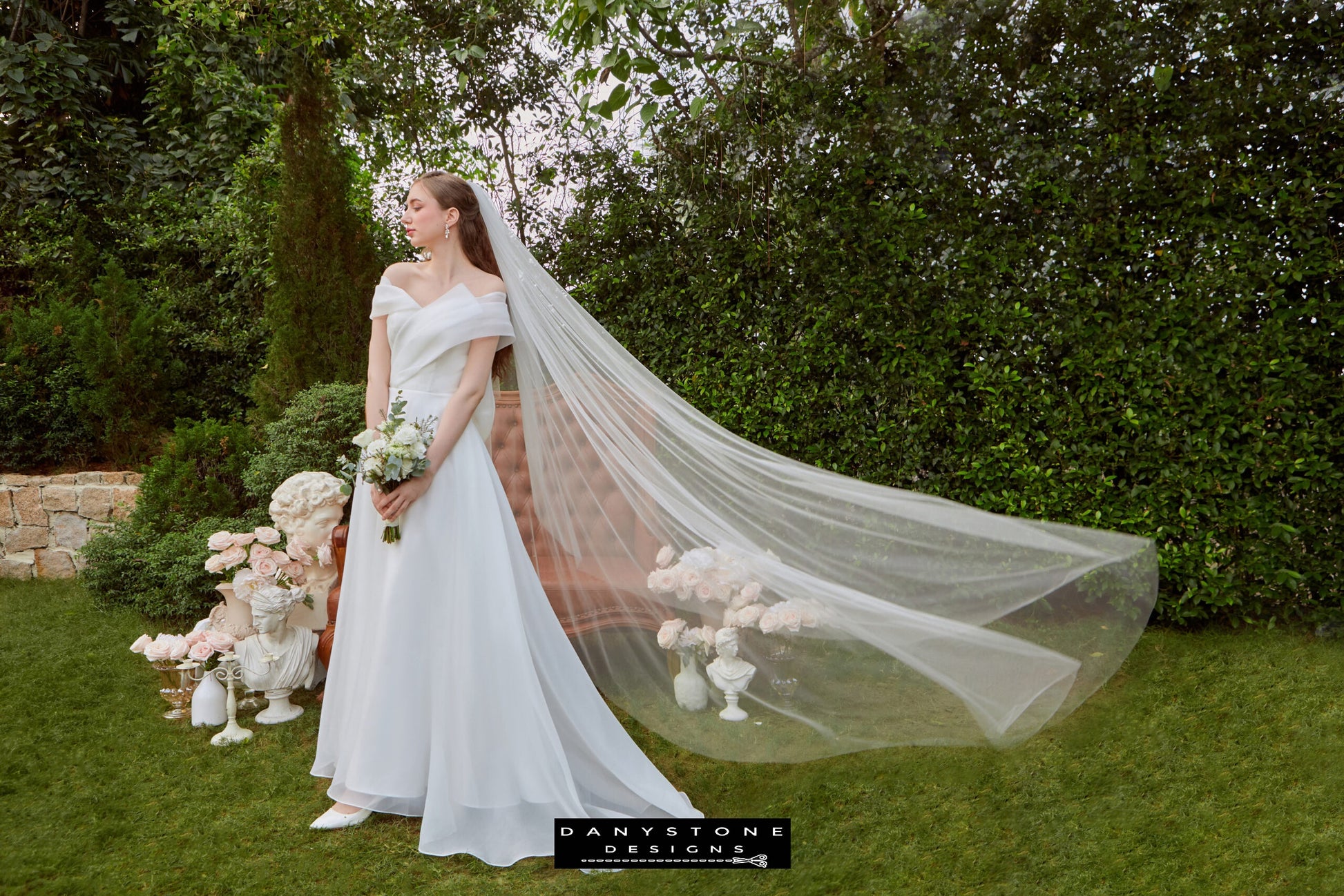 Off-the-Shoulder Silk Chiffon Bridal Gown - Model standing outdoors, highlighting the pleated silk chiffon bodice and sophisticated bow detail.