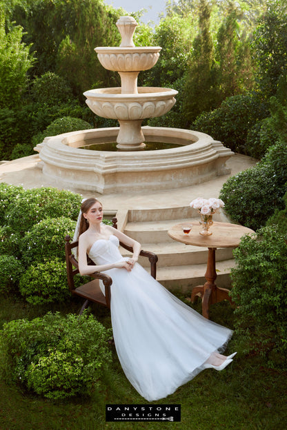 Bride standing in front of fountain wearing strapless wedding dress – Danystone Designs