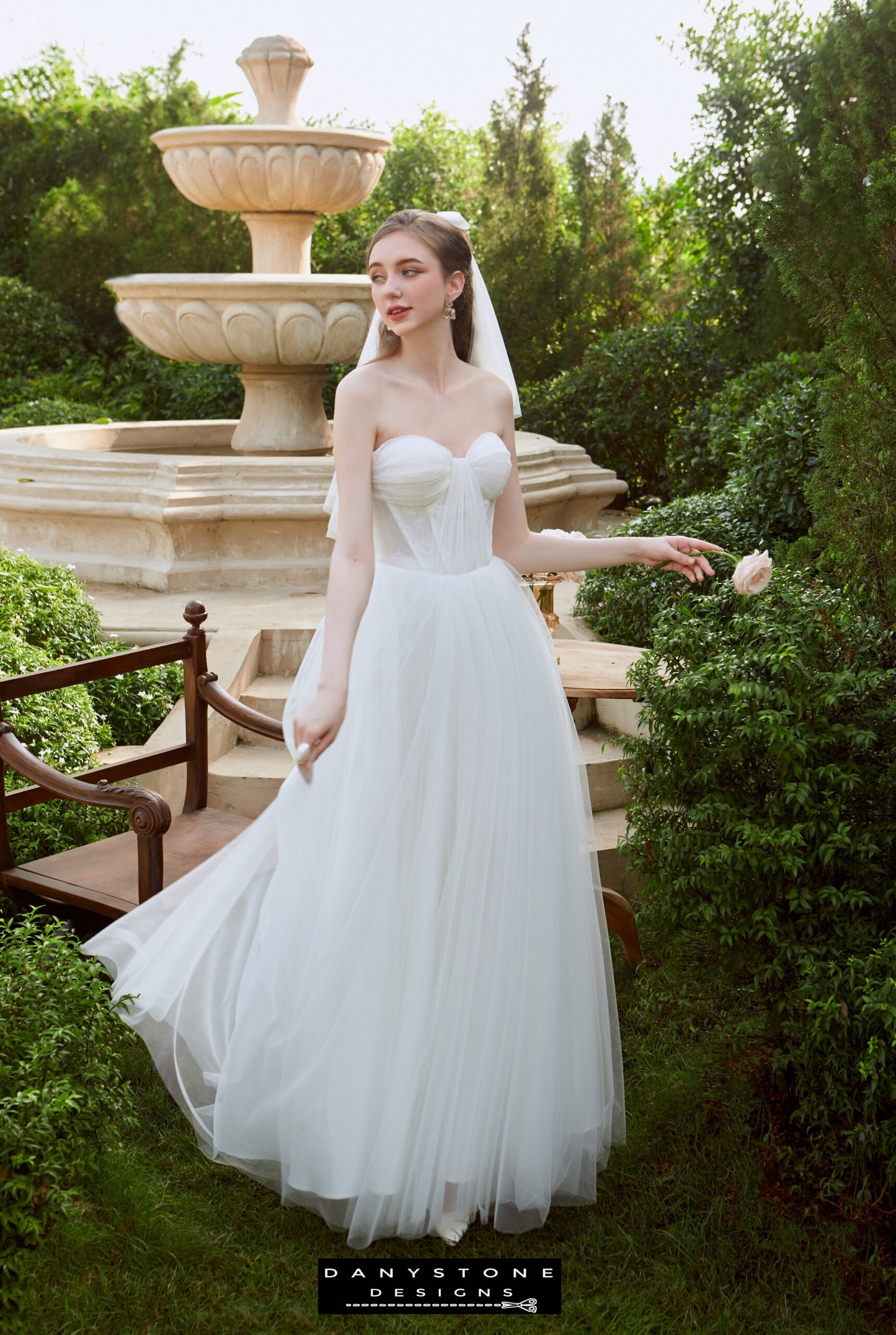 Bride posing on a wooden ladder in strapless wedding gown – Danystone Designs