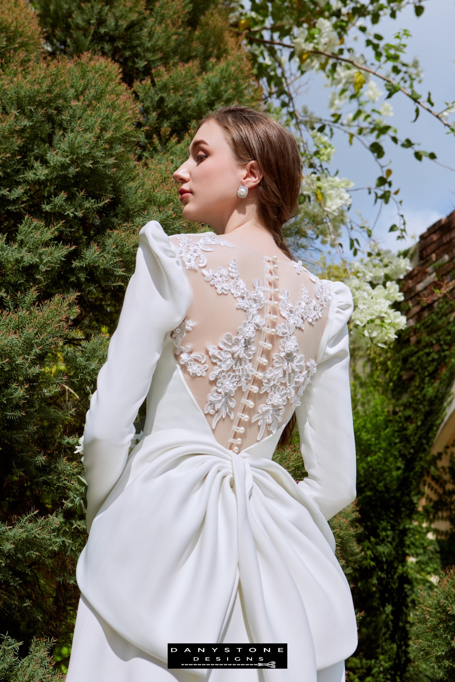 Snow White Queen Neck Satin Dress - Back View - Model showcasing the back view of the Snow White Queen Neck Satin dress with floral embroidery and large bow, standing in a garden.