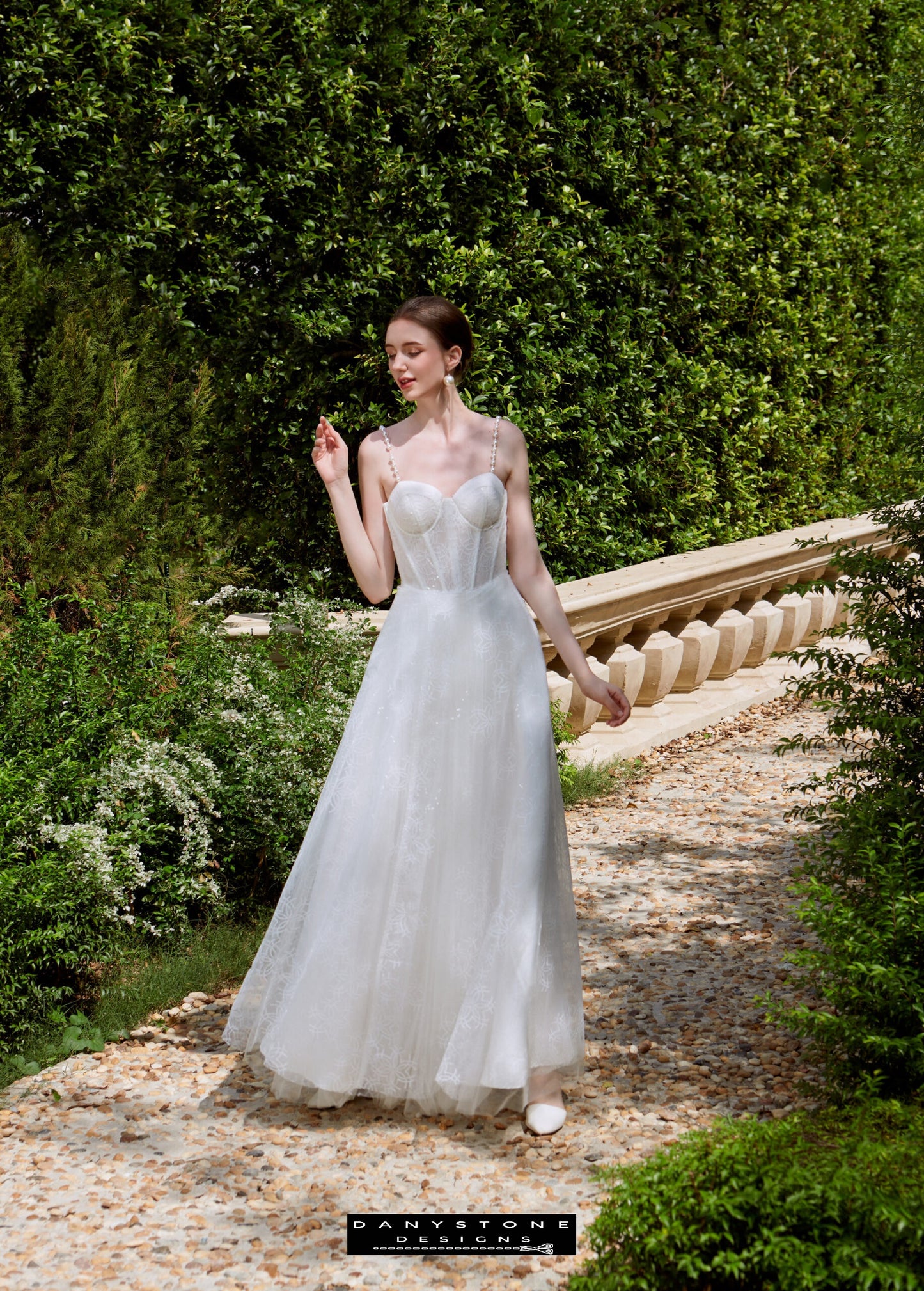 Cinderella Two-Strap Bridal Gown - Garden Setting - Model walking in a garden setting wearing the Cinderella two-strap bridal gown with a sweetheart neckline.