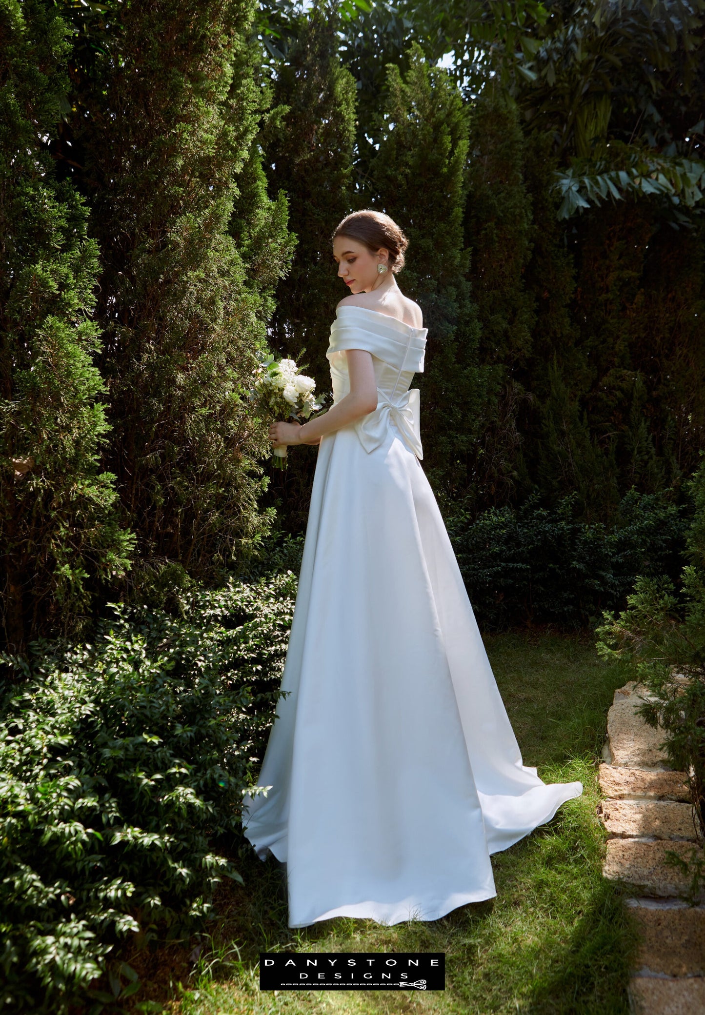 Back View of Cross-Breasted Dress with Pleated Bow - Model showing the back view of the dress, emphasizing the elegant pleated bow and flowing A-line silhouette.