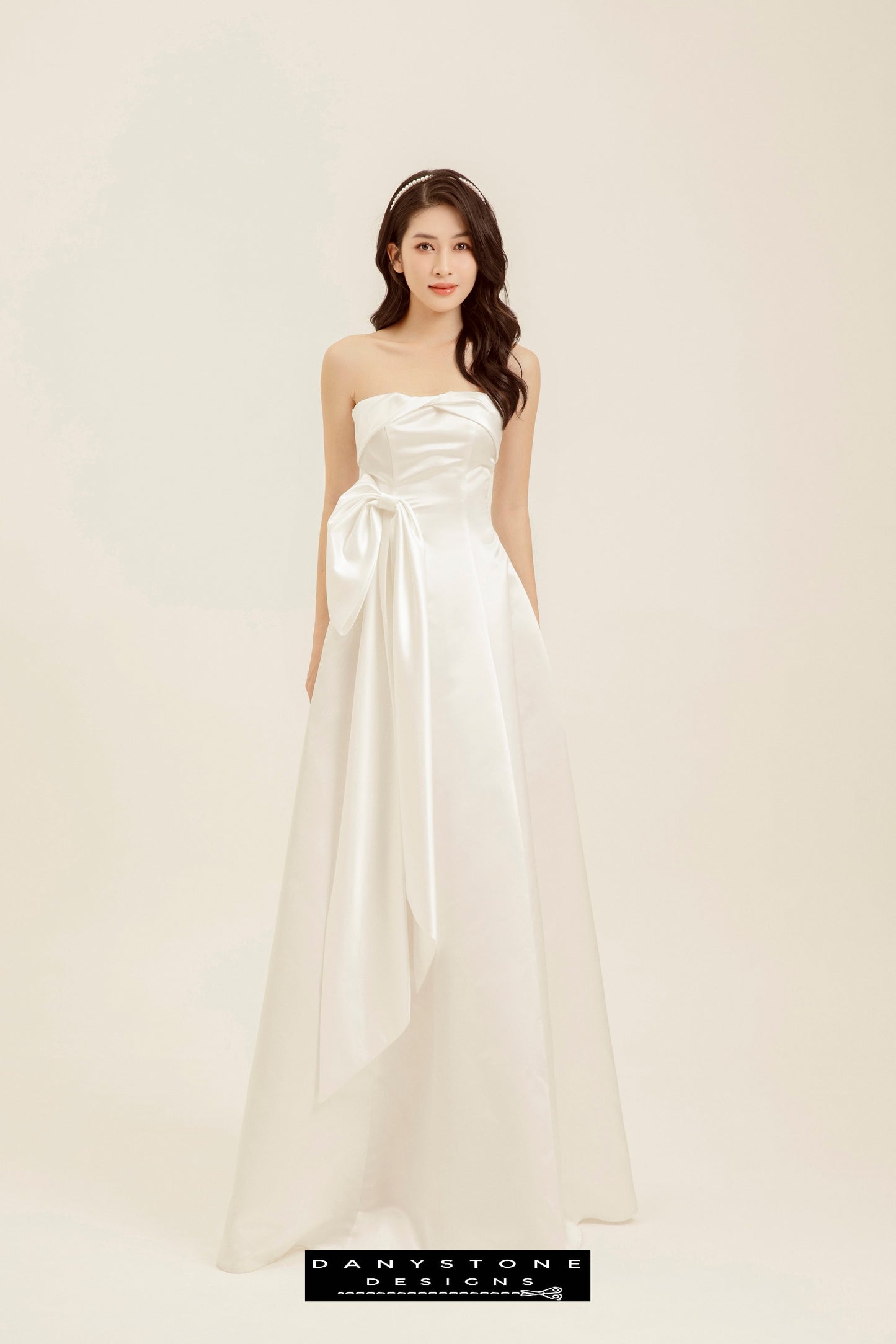 Full-length view of strapless wedding dress with bow detail and flowing skirt – Danystone Designs