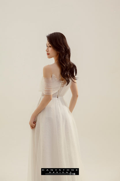 Model showing the back button closure and flowing skirt of the Beaded Floral Lace Pleated Wedding Dress.