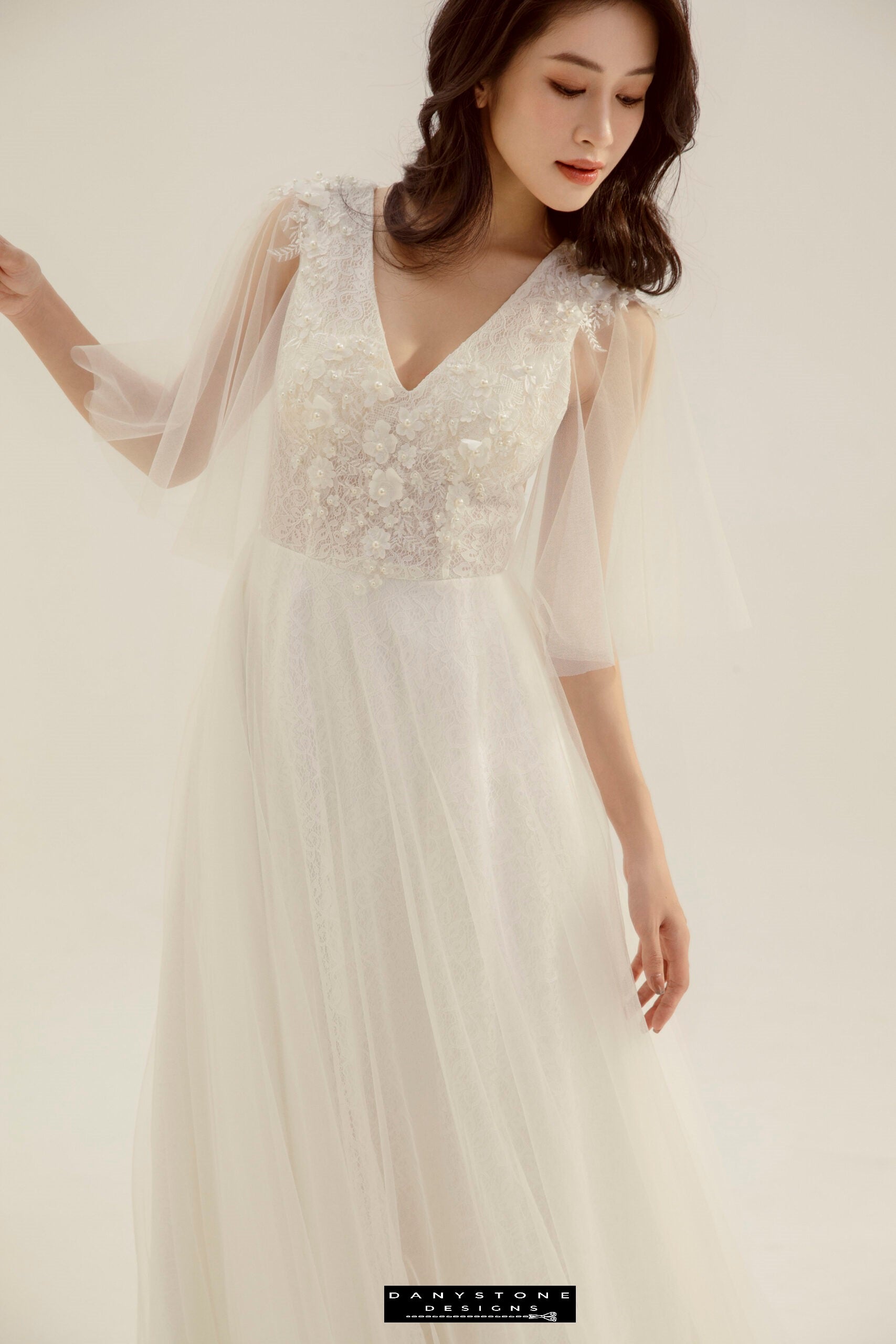 Close-up of a bride in a lace wedding dress with heart collar and fairy petals, showcasing the intricate lace details.