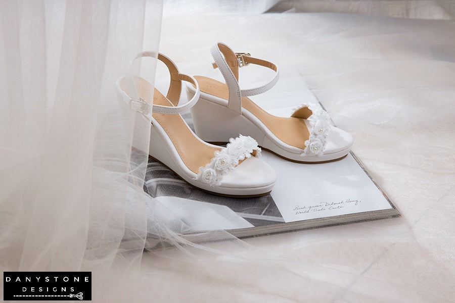 Close-up of matte white leather canoe heels with white rose lace trim, showcasing intricate lace details.