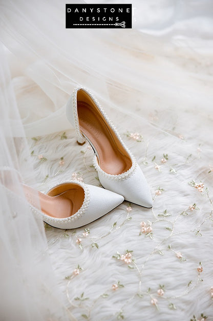 Close-up of pearl trim on wedding shoes, made from metallic scratched leather.