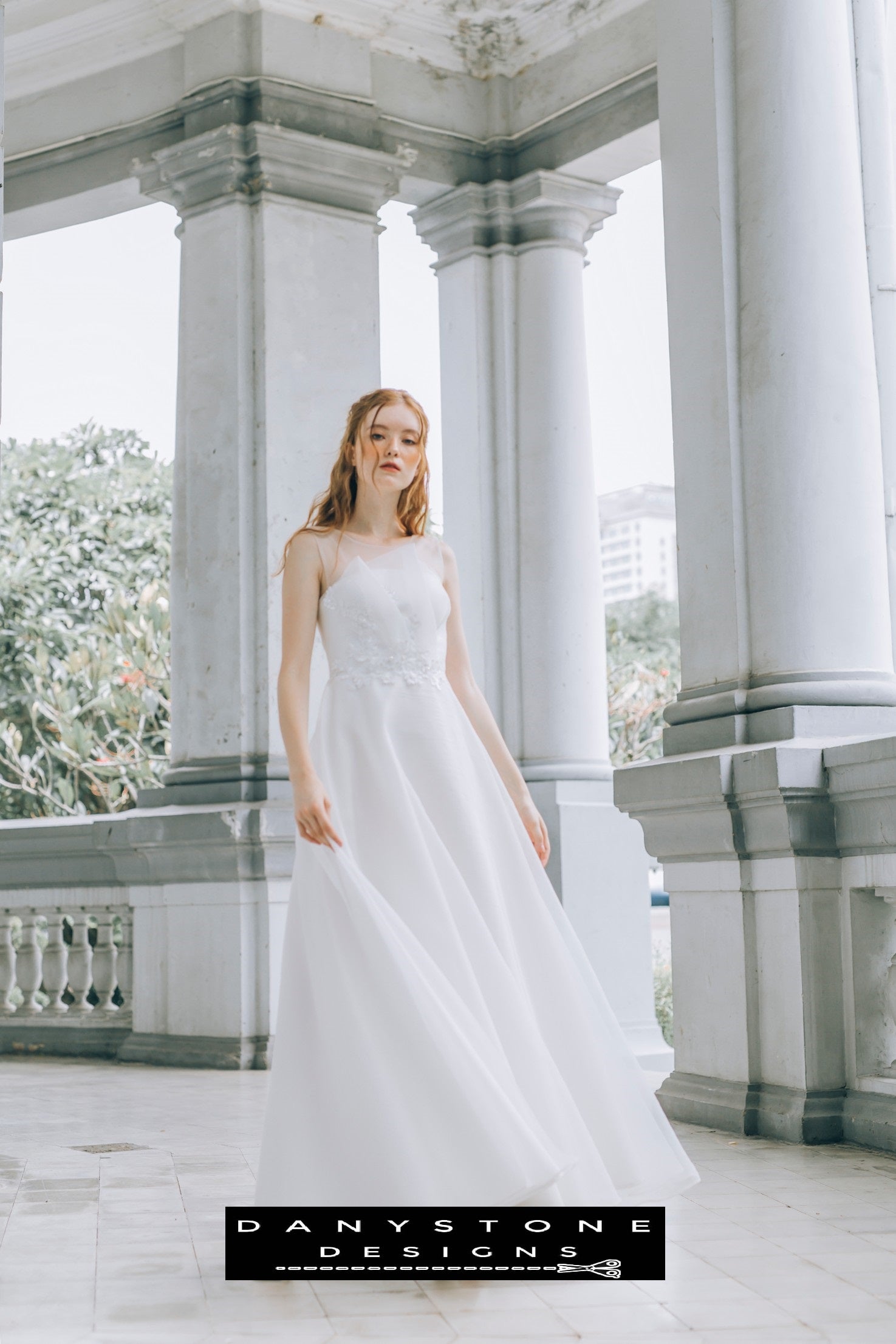 Bride looking down while wearing a pleated chest wedding dress with an illusion neckline