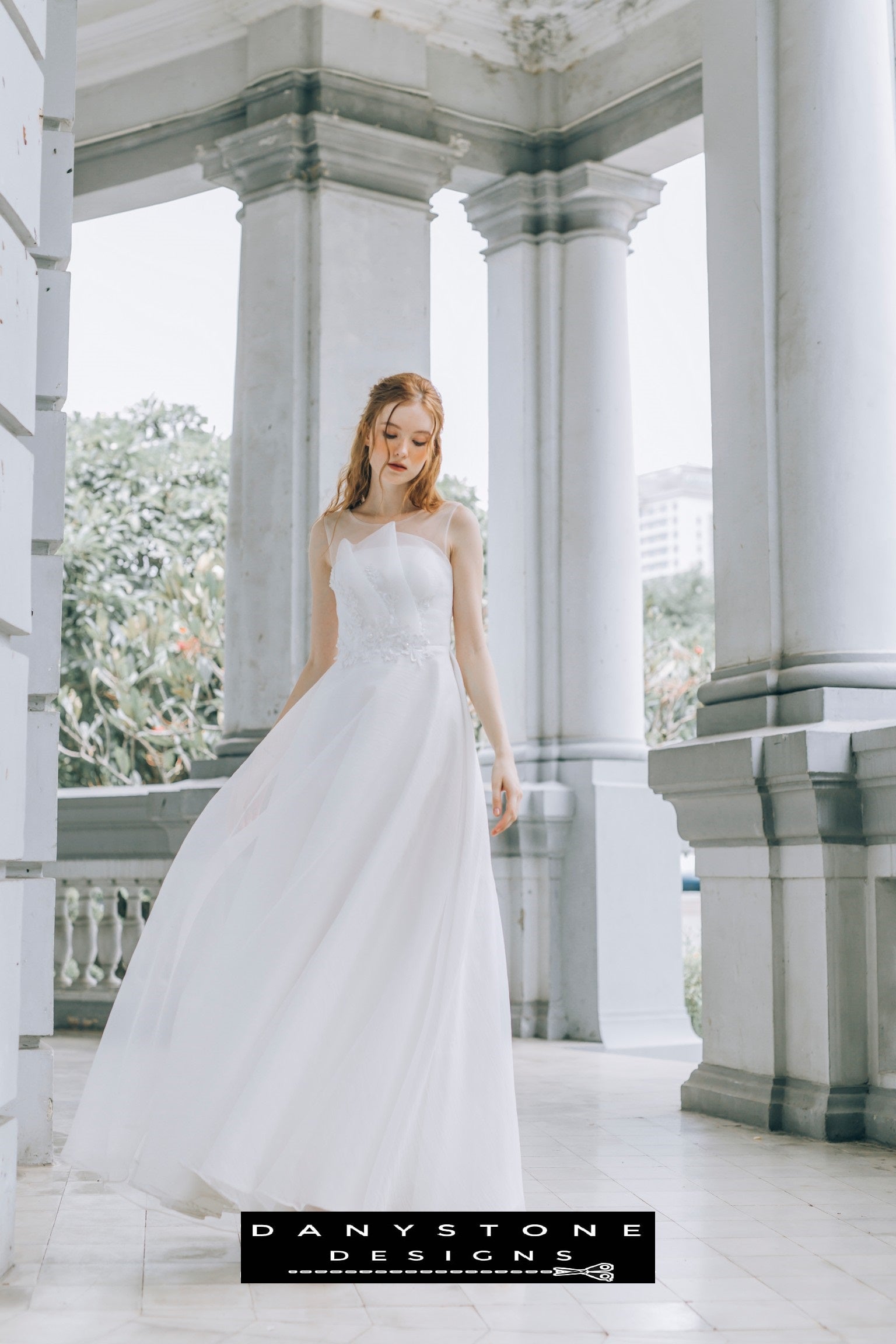 Bride looking down while wearing a pleated chest wedding dress with an illusion neckline