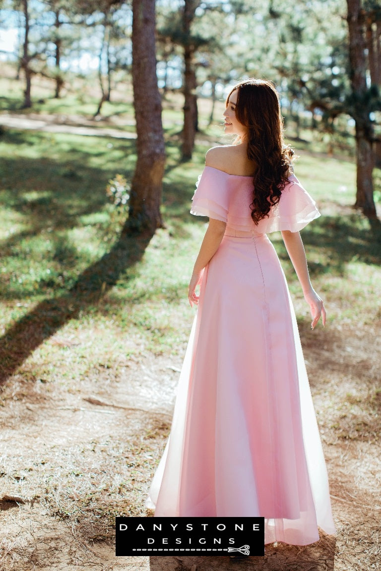 Model showcasing a romantic off-the-shoulder pink dress with silk chiffon layers