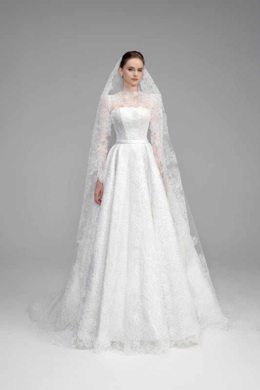 White wedding dress with a long veil on a gray background