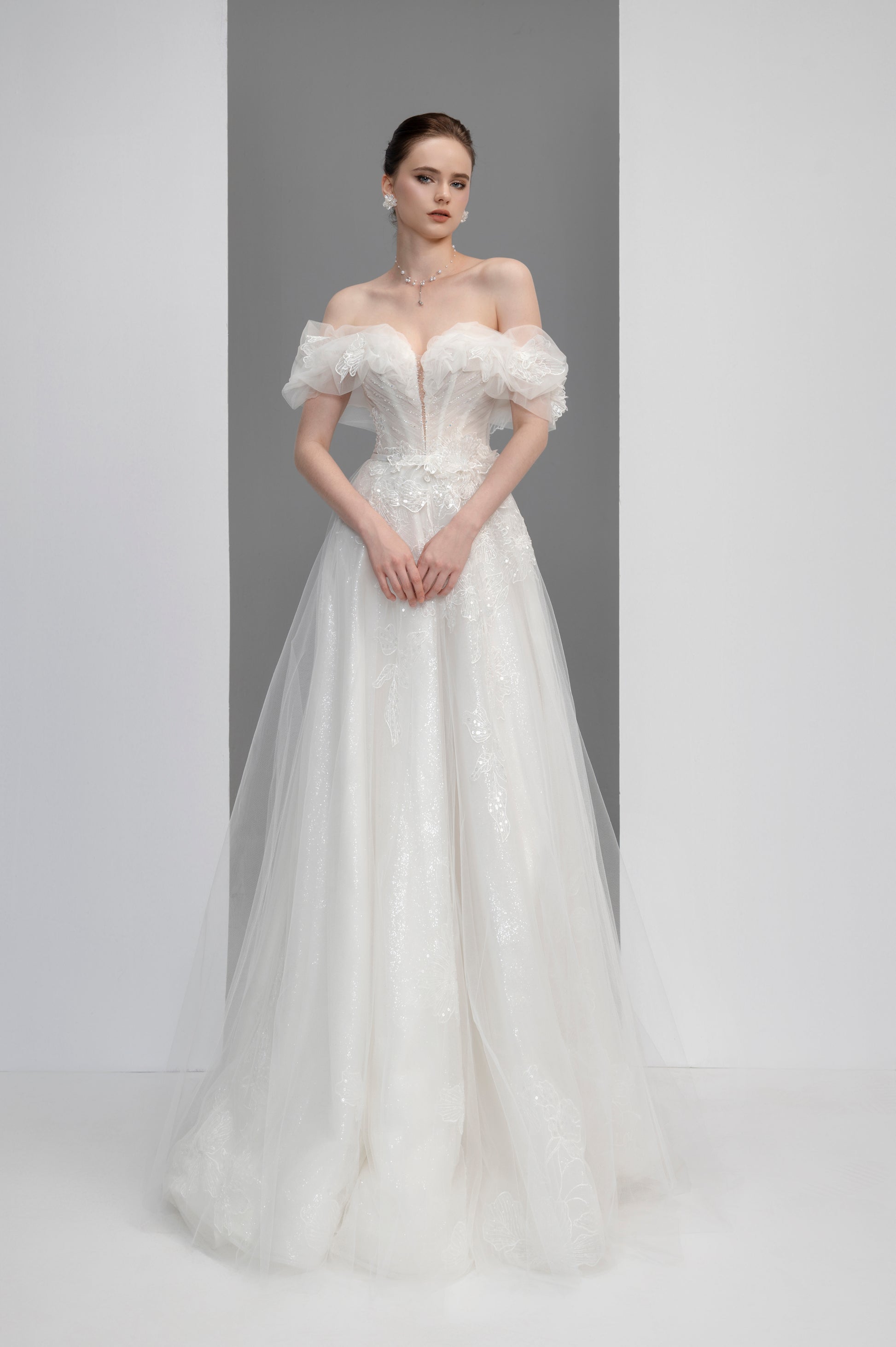 White wedding dress with floral details on a plain background