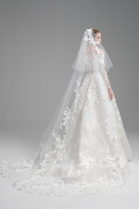 Elegant white wedding dress with a long veil on a gray background