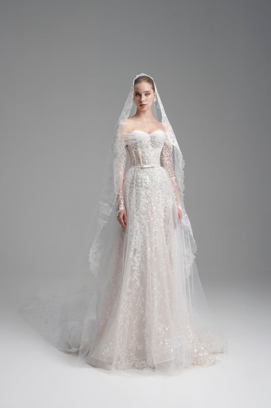 Bride in a white wedding dress with a veil against a gray background