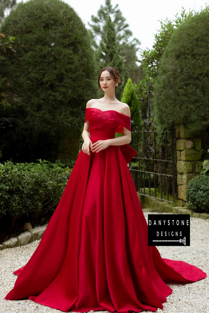 Bride in Puffy Chiffon Off-the-Shoulder Wedding Dress with Red Bow in Garden Setting