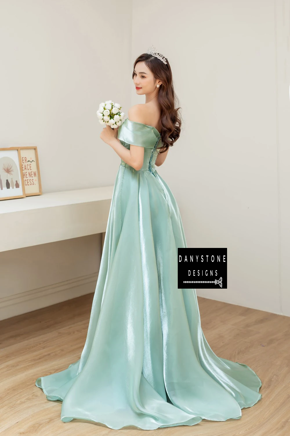 Bride in Moss Green Off-the-Shoulder Silk Wedding Dress with Bow Holding Flowers