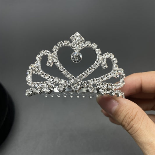 Small half-round bridal crown with white stones, held in hand, showcasing its delicate design.