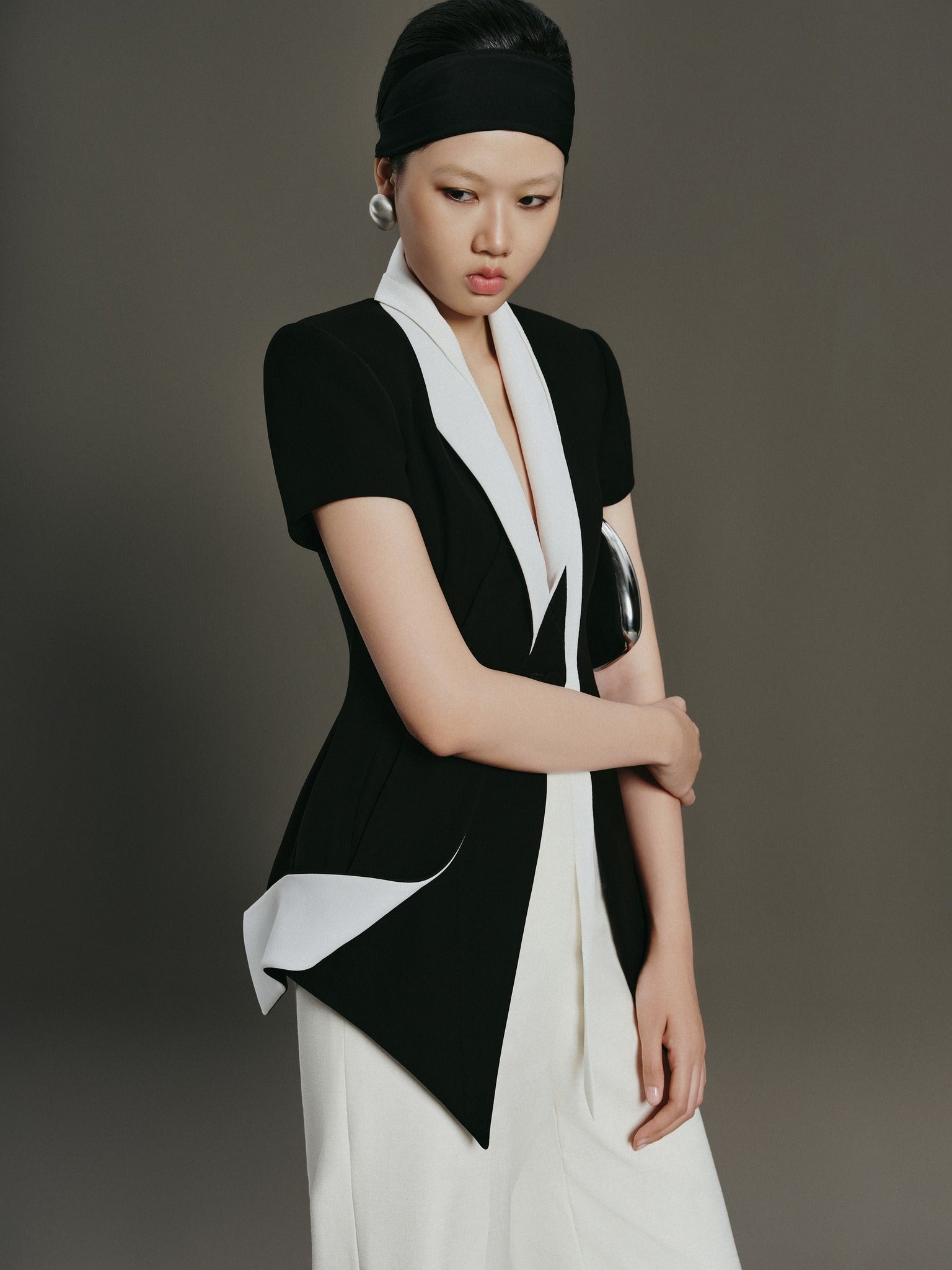 Woman wearing a black and white outfit against a gray background