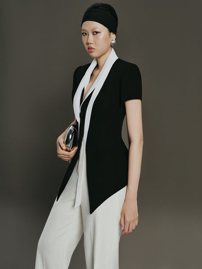 Woman wearing a black and white outfit against a gray background