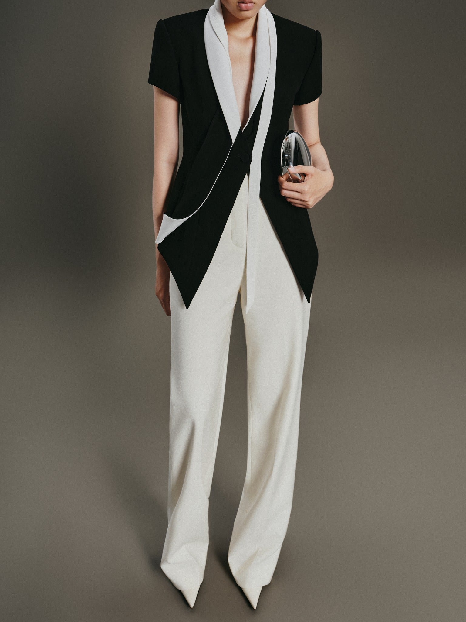 Person wearing a black and white outfit with a plain background