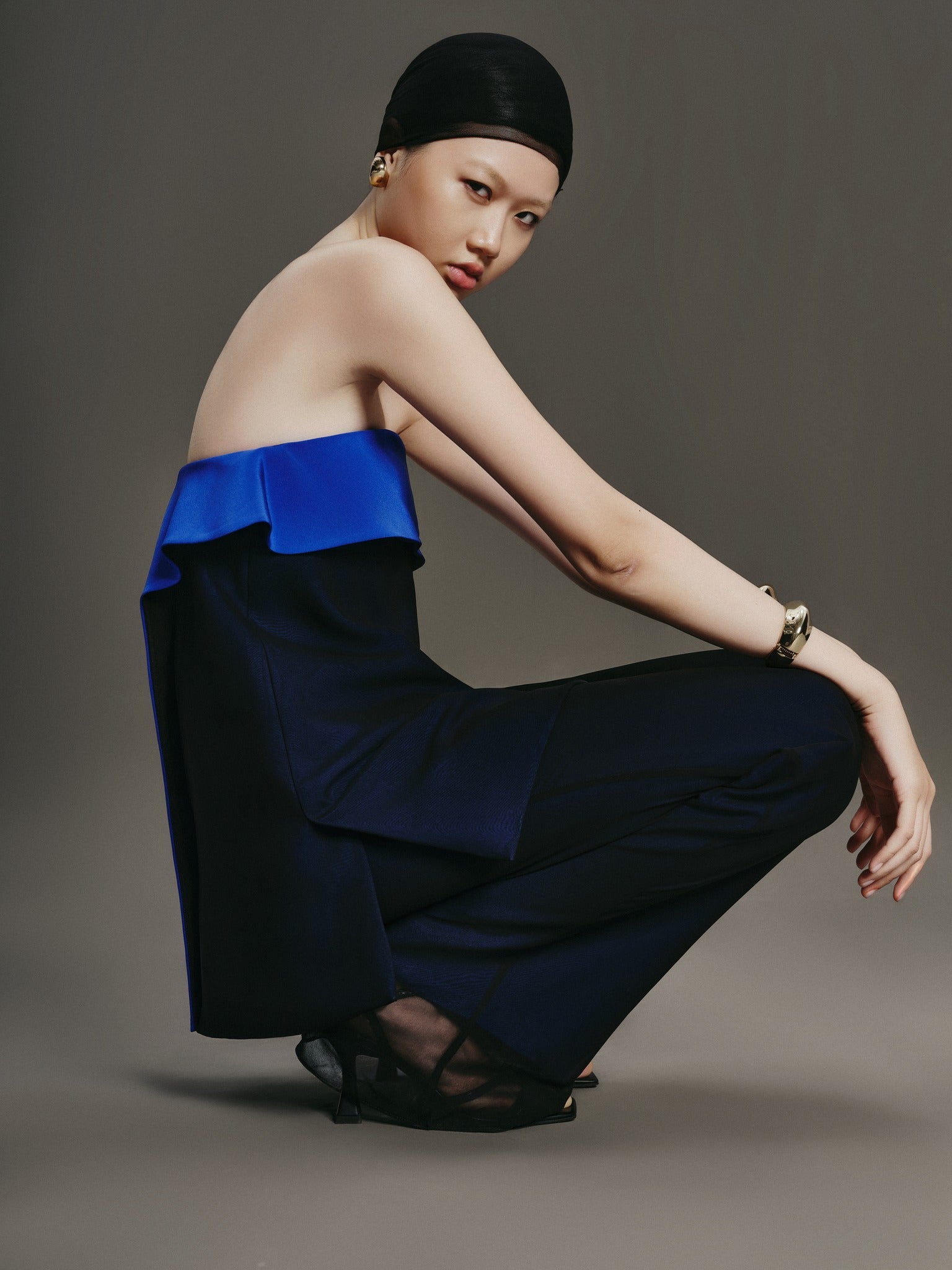 Woman wearing a blue and black outfit on a gray background