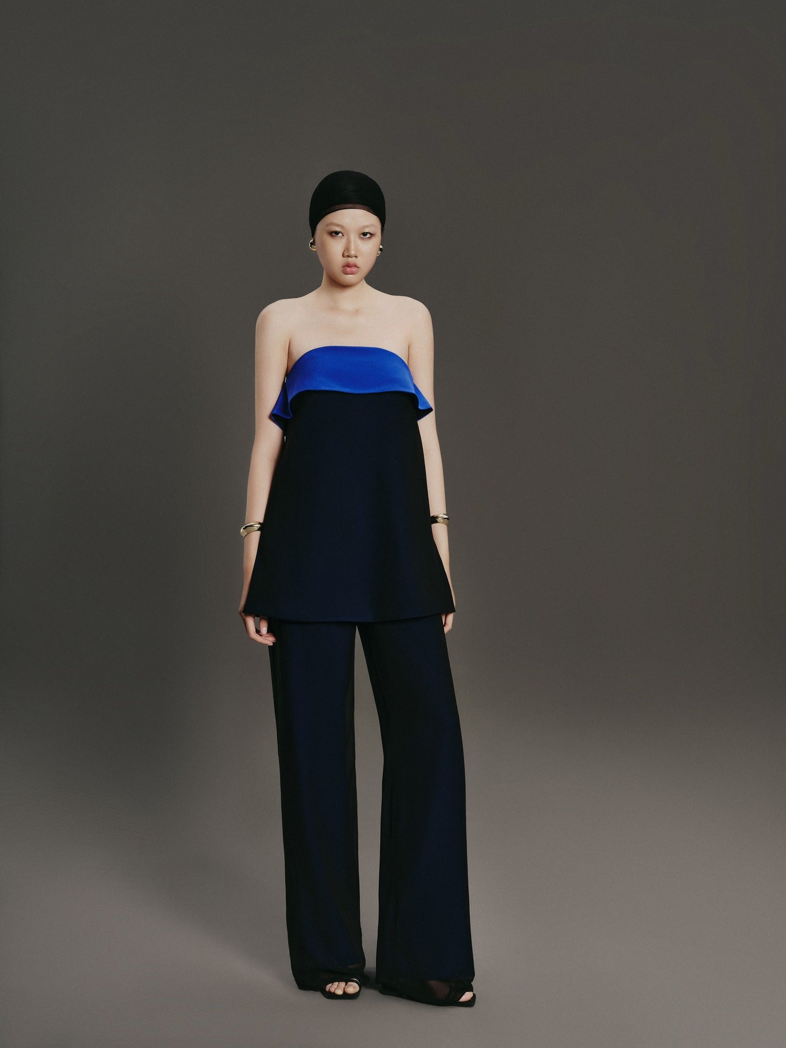 Woman wearing a blue and black outfit against a gray background