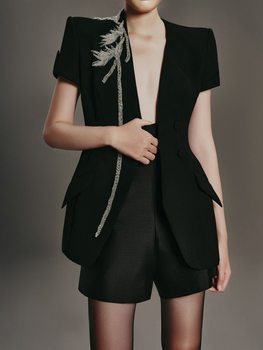 Black blazer with feather details on a plain background