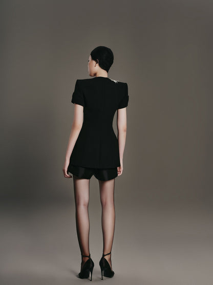 Woman wearing a black dress against a gray background