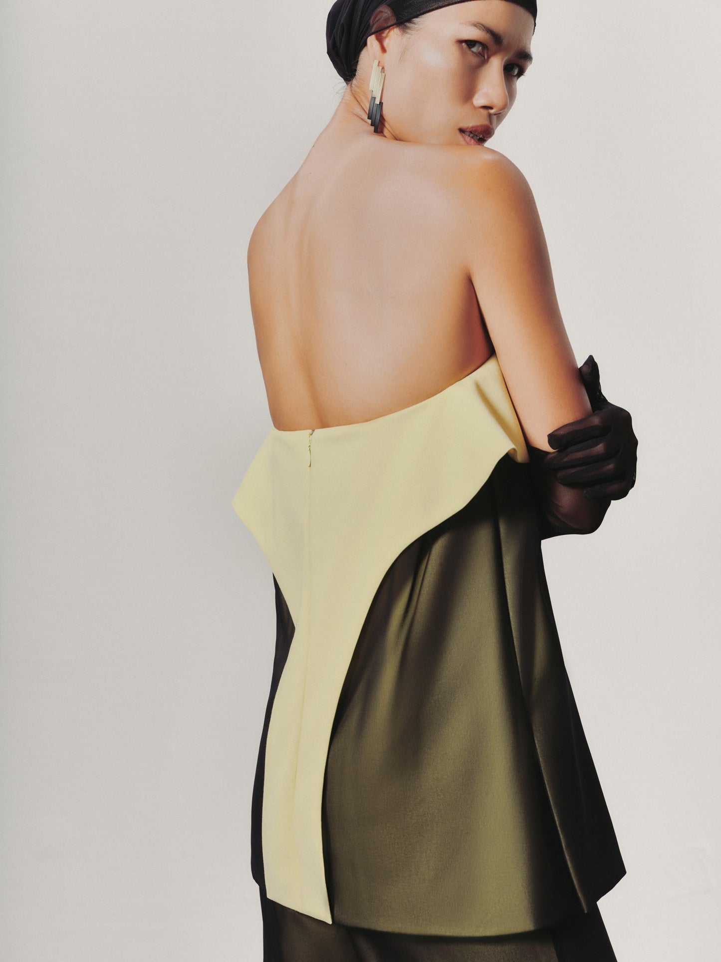 Woman wearing a two-tone dress with a plain background