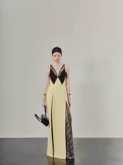 Woman wearing a yellow and black dress with sheer panels on a gray background