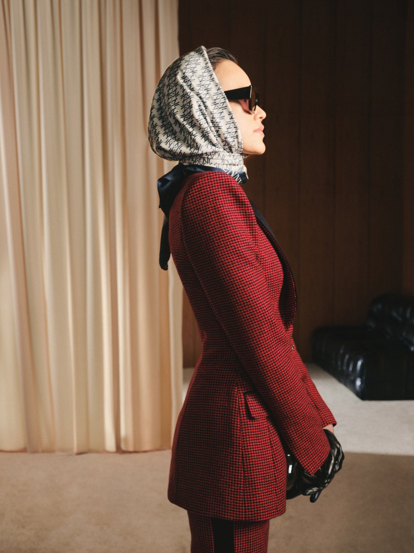 Person wearing a red suit and patterned headscarf in an indoor setting