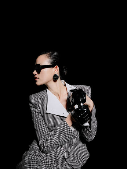 Person holding a camera against a black background