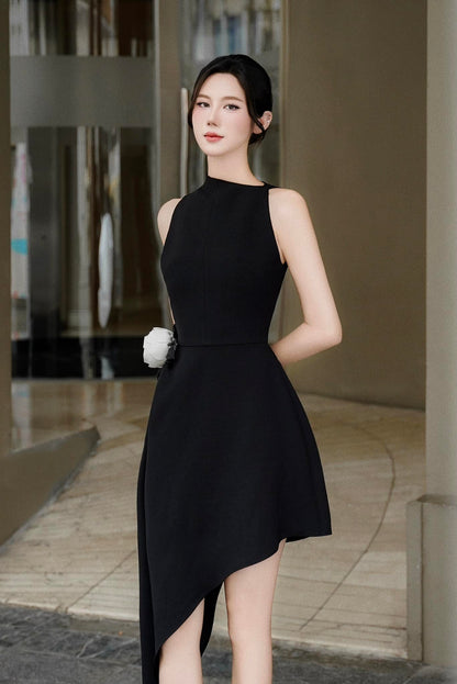 Woman in a black dress standing outdoors with a blurred background