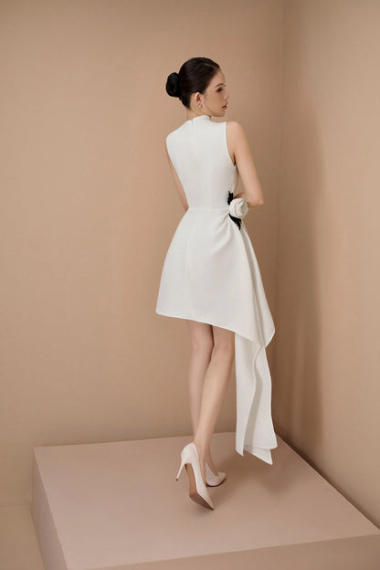 Woman wearing a white dress with a bow detail on a beige background
