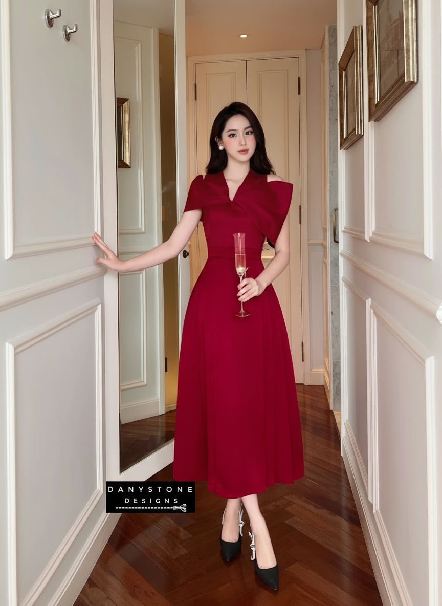 Woman in a red dress holding a glass in a hallway