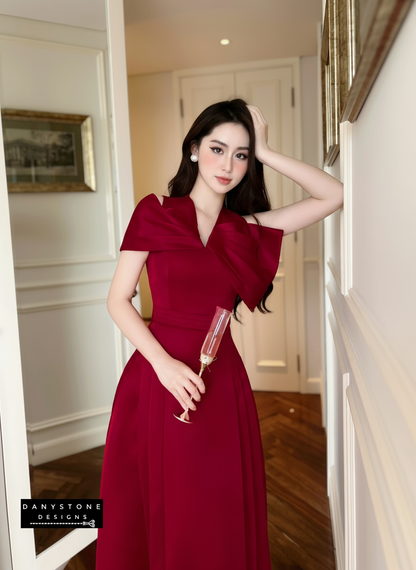 Woman in a red dress holding a glass in an indoor setting