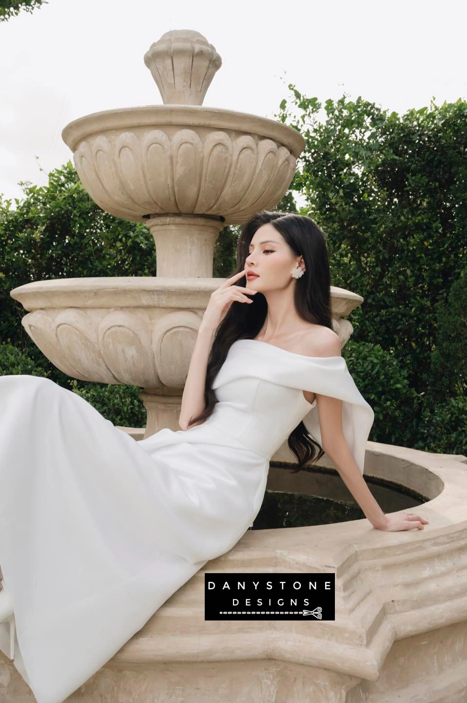 Model showcasing stylish one-sided pleated flared shoulder dress in white