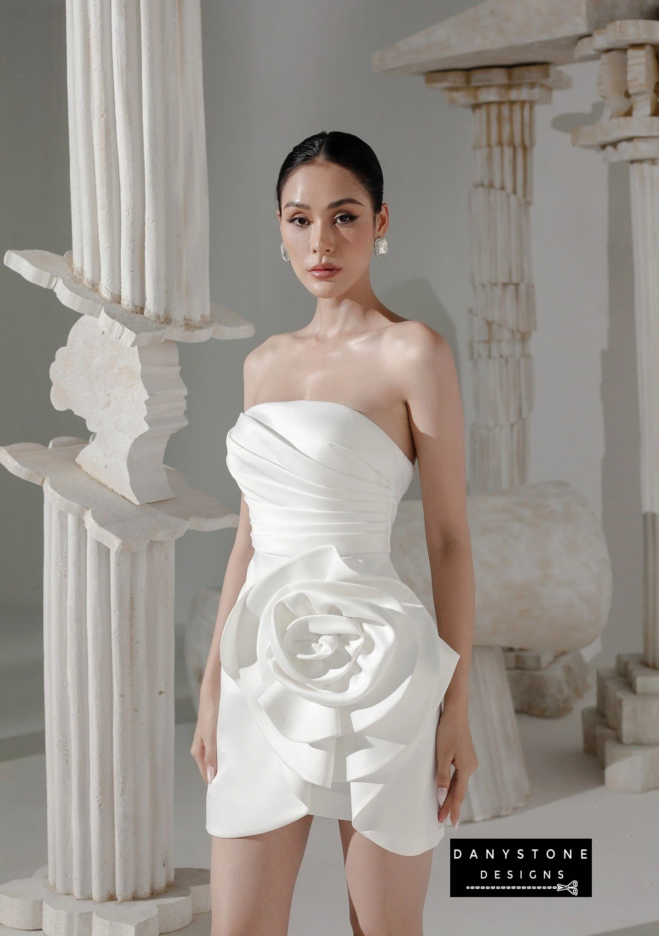 Model showcasing floral strapless bodycon dress with pleated waist in white