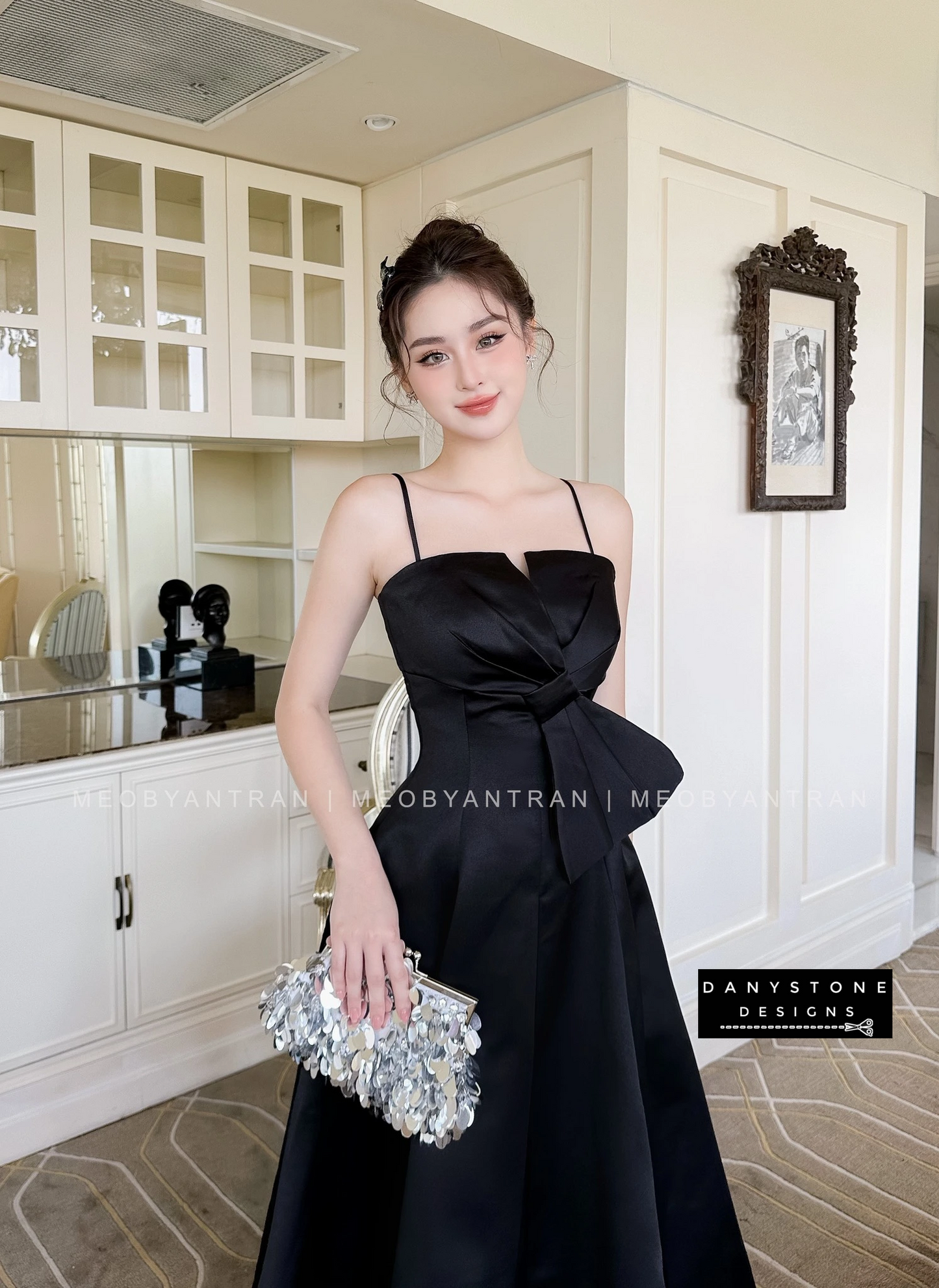 Model in Black 2-Strap Bow Accent Dress in Elegant Room