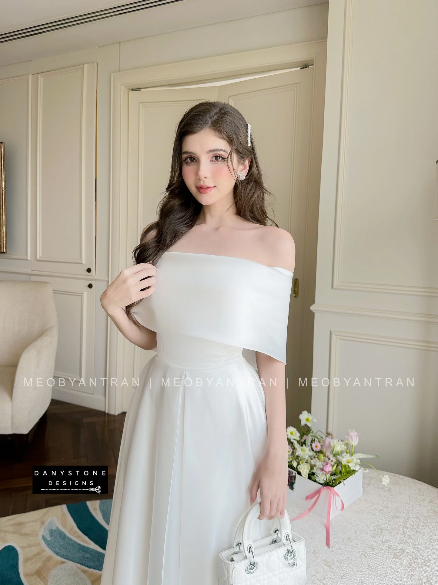 Model in White Off-Shoulder Party Dress in Sophisticated Setting